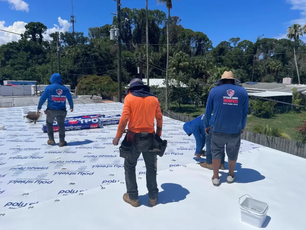 Three commercial roofers working on a flat roof on the Florida Gulf Coast