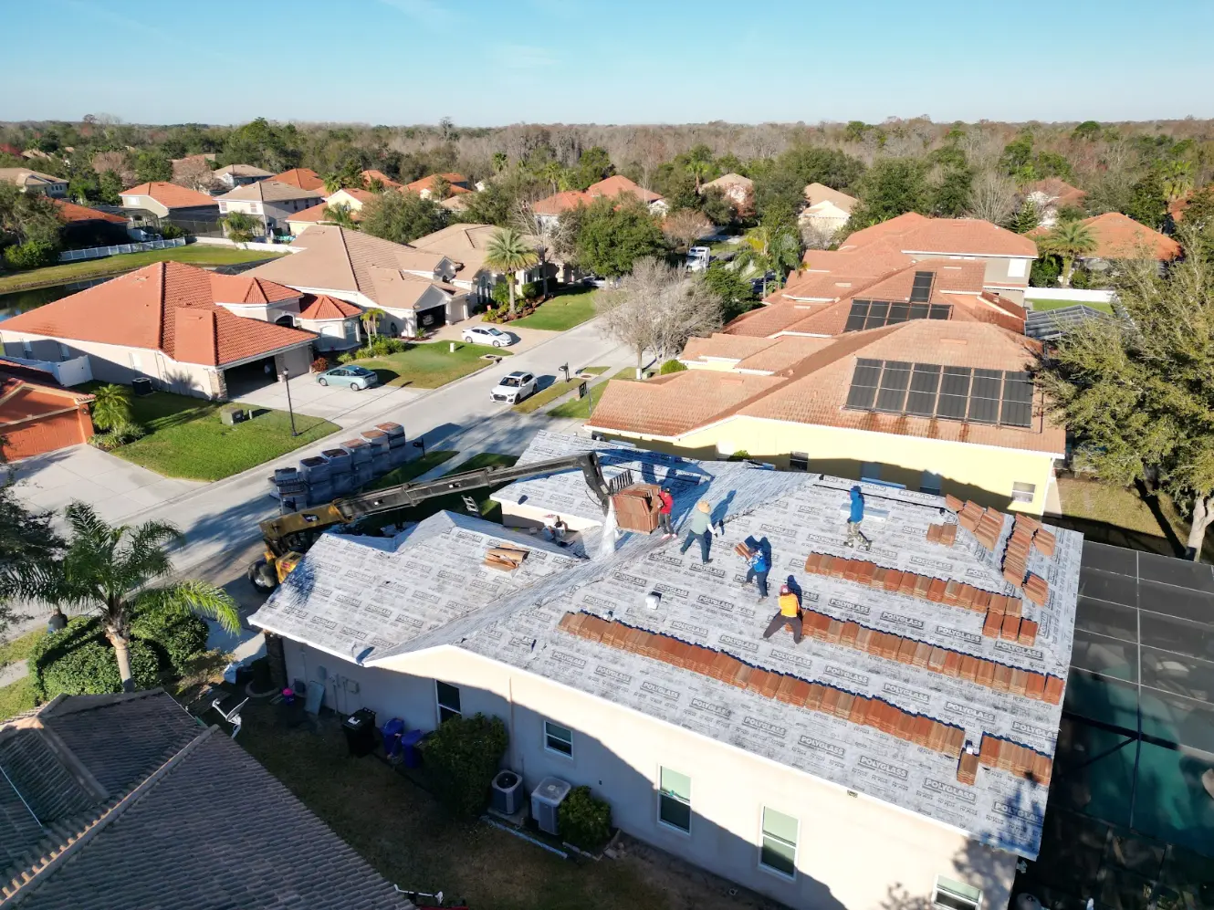 Aerial view of roofers installing a new roof on a New Port Richey home